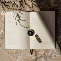 ritual journal with a crystal on a textured surface