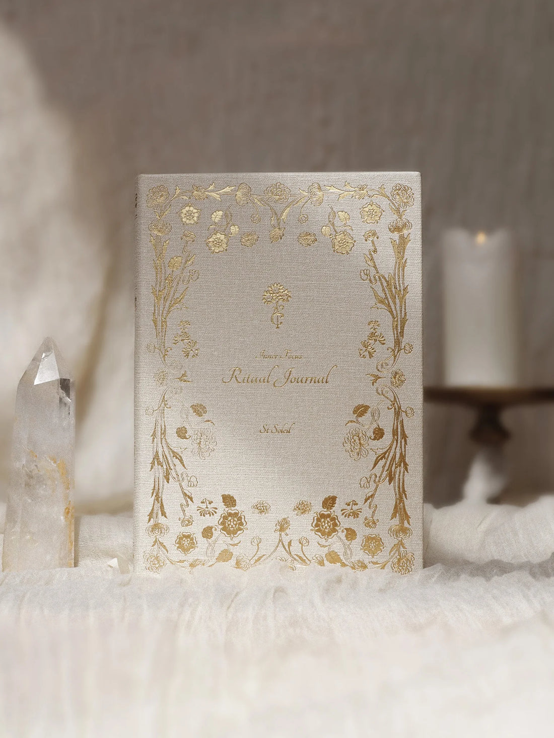 Decorative notebook with gold floral patterns on a soft white surface