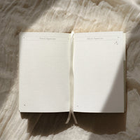 Open ritual journal on a textured fabric surface