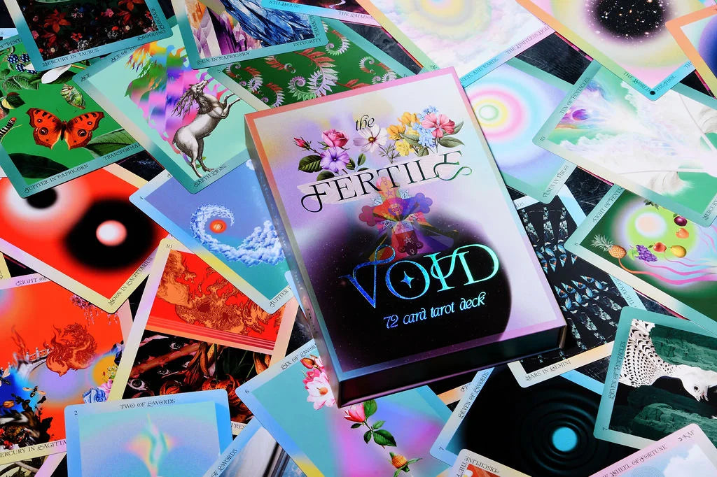 A colorful card deck box labeled 'FERTILE VOYD' sits on top of a scattered pile of illustrated tarot cards with psychedelic and fantasy artwork.